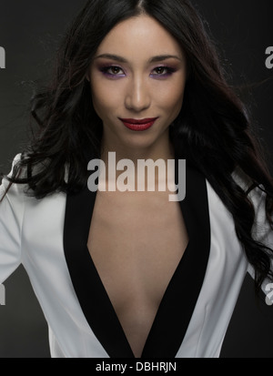 Schöne asiatische Frau in ihren Zwanzigern, mit schwarzen und weißen Jacke braless Stockfoto