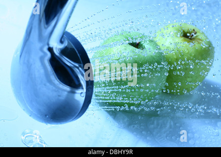 Apfel waschen unter Wasser nass Stockfoto