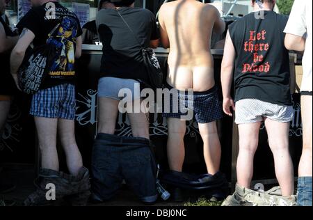 Wacken, Deutschland. 31. Juli 2013. Festival-Besucher stehen mit ihrer Hose nach unten am Bier-Stand auf dem Festivalgelände in Wacken, Deutschland, 31. Juli 2013. Etwa 75.000 Heavy-Metal-Fans dürften beim 24. Wacken Open Air in der Kleinstadt mit 1.800 Einwohnern. Foto: CARSTEN REHDER/Dpa/Alamy Live News Stockfoto