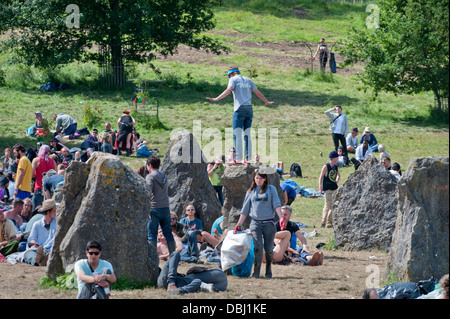 Glastonbury Festival 2013 UK - Mann balancieren auf eines der Menhire Stockfoto