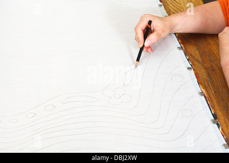 Künstler zeichnet Skizze auf Seide für kalte Batikmalerei Stockfoto