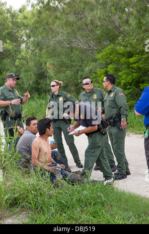 Border Patrol Agenten Frage Einwanderer aus Mittelamerika nach ein van mit 26 auf einem Texas Highway stürzte. Stockfoto