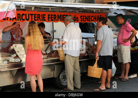 Shopper-Warteschlange auf einen Stand auf dem Samstags-Markt in der kleinen Stadt Genolhac in der Region Languedoc-Roussillon, Frankreich. Stockfoto