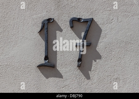 Metall-Nummer 17 an der Wand eines alten Hauses Stockfoto