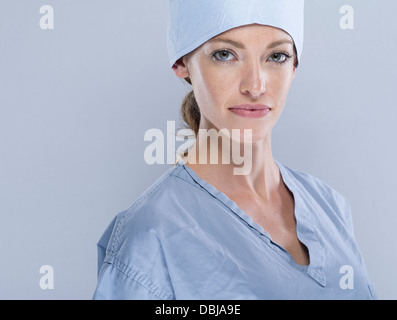 Weibliche Medic tragen scheuert sich chirurgische Kappe und Maske Stockfoto