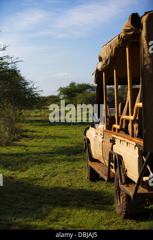 Safari-Jeep mit Blick auf den Kilimanjaro in der Ferne. Ol Kinyei Conservancy. Kenia, Afrika. Stockfoto