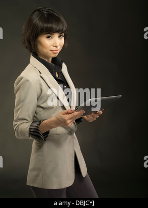 Junge schöne Frau in ihren Zwanzigern mit Apple iPad Tablet-computer Stockfoto