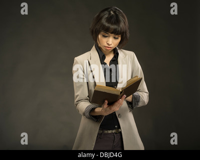 Junge schöne Frau in ihren Zwanzigern alte Hardcover Buch Stockfoto