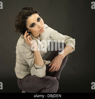 Junge schöne Frau in ihren Zwanzigern, mit ihrem Handy Stockfoto