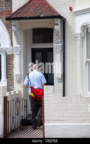 Postbote liefert Post, Wohnhaus in Wandsworth - London-UK Stockfoto