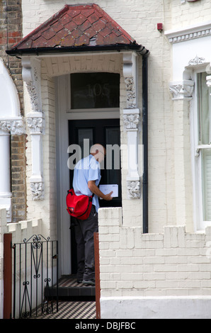 Postbote liefert Post, Wohnhaus in Wandsworth - London-UK Stockfoto