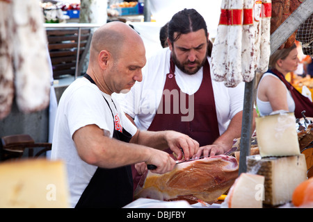 Händler, schnitzen Palma Schinken in der Altstadt von Pollensa Sonntagsmarkt der Hauptplatz Plaza Mayor entfernt. Stockfoto