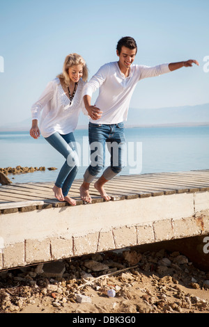 Kroatien, junges Paar am Strand springen Stockfoto