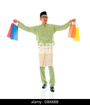 Traditionelle malaiische männlichen Einkaufs- und springen in Freude während Hari Raya Ramadan Aidilfitri festival Stockfoto