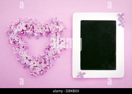 Lila lila Blume Herz auf strukturierten Hintergrund und eine leere Tafel für textfreiraum für Nachricht oder Gruß Stockfoto