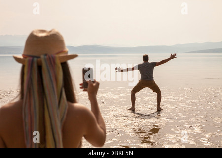 Kroatien, junge Frau am Strand fotografieren Stockfoto