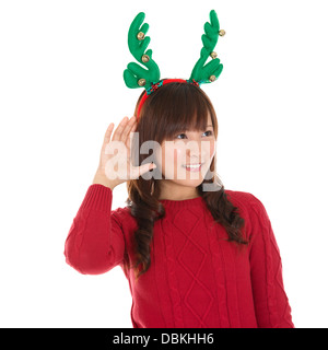 Junge Asiatin Weihnachten hören isoliert auf weißem Hintergrund, asiatischen weiblichen Modell. Stockfoto