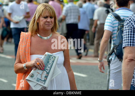 Manchester, UK. 1. August 2013. Eine Frau trägt eine Kopie von The Cricket-Papier auf ihrem Weg zum dritten Test Match zwischen England und Australien im Emirates Old Trafford, Manchester, UK. Bildnachweis: John Fryer/Alamy Live-Nachrichten Stockfoto