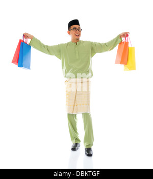 Traditionelle malaiische männlichen Einkaufs- und springen in Freude während Hari Raya Ramadan Aidilfitri festival Stockfoto