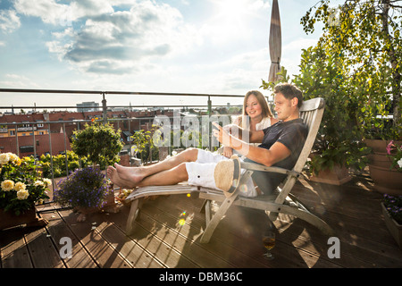 Paar auf Balkon mit Handy, München, Bayern, Deutschland, Europa Stockfoto