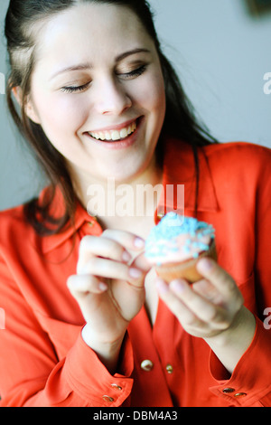 Frau im roten Kleid Essen einen Cupcake, Kopenhagen, Dänemark Stockfoto
