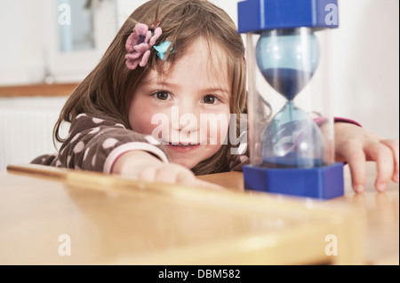 Kleines Mädchen mit Sanduhr In Kindergarten, Kottgeisering, Bayern, Deutschland, Europa Stockfoto