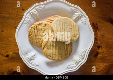 Hausgemachte Erdnussbutter Plätzchen, frisch gebacken und auf einem weißen Teller, Holztisch. USA. Stockfoto