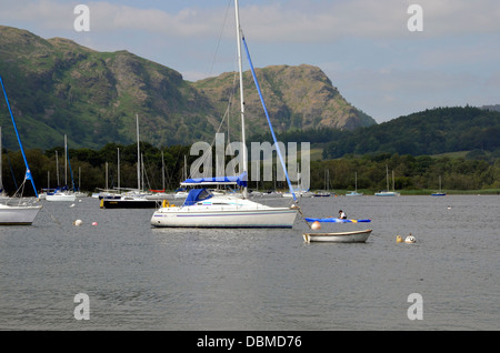 Segelboote vor Anker am Coniston Water neben Coniston Segelclub mit Seenplatte Bergen im Hintergrund. Stockfoto