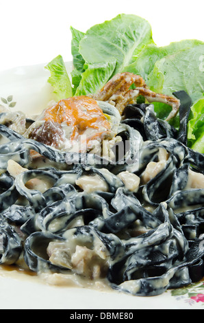 schwarze Tagliatelle (Nudeln mit Tintenfisch-Tinte gemacht) mit Carbonara-Sauce, Gebratene Krabben und frisches Gemüse auf Platte hautnah Stockfoto