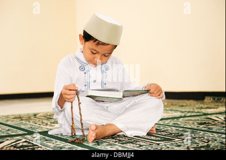 Muslimische Junge liest Koran In eine Moschee Stockfoto