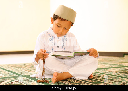 Muslimische Junge liest Koran In eine Moschee Stockfoto