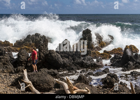 Tourist am Strand und Wellen auf Keanae Peninsula, entlang der Straße nach Hana auf Maui in Hawaii. Stockfoto