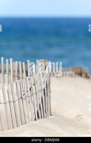 Ein Holzzaun am Sandstrand am Meer-Ufer. Stockfoto