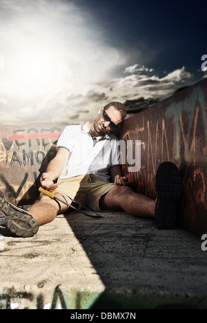 fehlgeschlagene Arbeiter liegen auf dem Boden halb betrunken Stockfoto