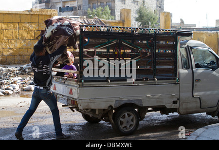 Ein Mann lädt einen LKW in der Nähe der Frontlinie in Karm Al Jabal. Man kehrte nach Hause zurück, während der Eid Al Adha Urlaub Possessio sammeln Stockfoto