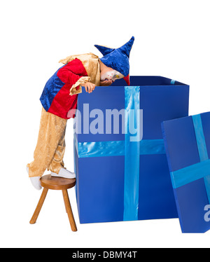 Lustige Jester Clown Mädchen schauen tief in einen großen blauen Überraschungs-box Stockfoto