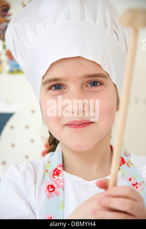 Kleines Mädchen mit Kochmütze mit Holzlöffel, München, Bayern, Deutschland Stockfoto