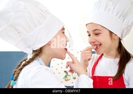 Zwei kleine Mädchen mit Kochmütze Scherz herum, München, Bayern, Deutschland Stockfoto