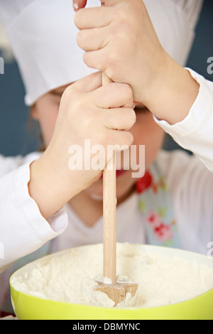 Kleines Mädchen mit Kochmütze vorbereitet Teig, München, Bayern, Deutschland Stockfoto