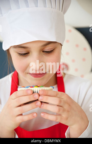 Kleines Mädchen Blick auf bunten Muffin, München, Bayern, Deutschland Stockfoto