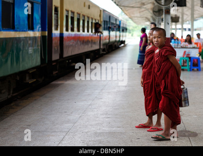 Zwei nicht identifizierte junge Novizen warten auf den Zug am Hauptbahnhof in Yangon, Myanmar Stockfoto