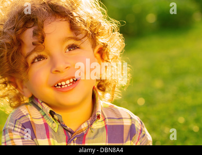 Nahaufnahme Foto glücklich kleinen Jungen Spaß auf frischen grünen Rasen im Park, entzückenden Kind genießen Sonnentag Stockfoto