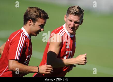 Bayern Mario Goetze (L) und Bastian Schweinsteiger Jogg während einer Trainingseinheit am Trainingsgelände des Vereins Saebener Straße in München, Deutschland, 2. August 2013. Foto: ANDREAS GEBERT Stockfoto