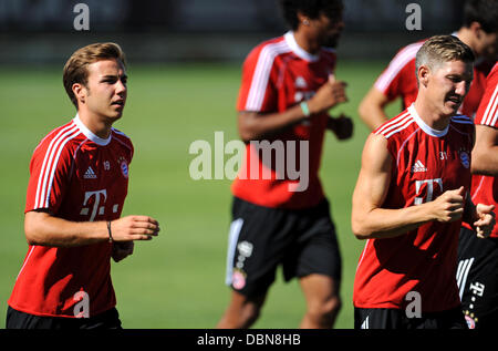 Bayern Mario Goetze (L) und Bastian Schweinsteiger (R) Jogg während einer Trainingseinheit am Trainingsgelände des Vereins Saebener Straße in München, Deutschland, 2. August 2013. Foto: ANDREAS GEBERT Stockfoto