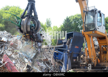 Kran Schrott in Müllpresse am Schrottplatz für Pressen vor dem Transport zum Schmelzen von Vereinigtes Königreich neu laden Stockfoto