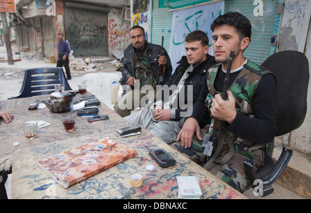 1. November 2012 - Aleppo, Syrien: Freie Syrische Armee Kämpfer Mann ein Scheck zeigen und Handys zu halten. Stockfoto