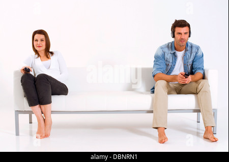 paar auf der Couch vor dem Fernseher getrennt Stockfoto