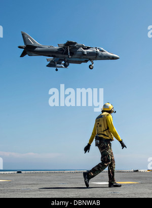 Ein US-Marine Aviation Boatswain Mate Uhren eine AV-8 b II Harrier Kampfjet landet auf dem Flugdeck der amphibischen Angriff Schiff USS Wasp 23. Juli 2013 in Betrieb im Atlantischen Ozean. Stockfoto