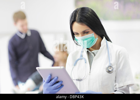 Ärztin mit Mundschutz mit digital-Tablette, Osijek, Kroatien Stockfoto