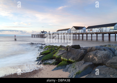 Southwold Pier, Strand und Meer Abwehrkräfte an einem Sommermorgen bei Sonnenaufgang. Stockfoto